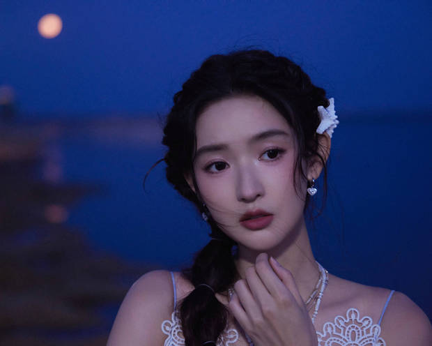 搜狐娱乐讯 5月14日，王玉雯一组夏日美照释出，照片中她穿蓝白色吊带长裙清冷优雅，在夜色的海边拍照氛围感满满。